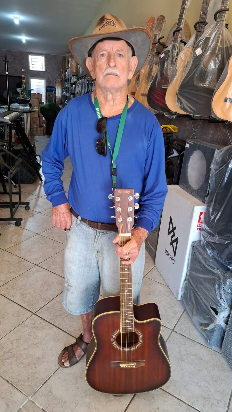 Músico com violão após conserto realizado pelo Demasom